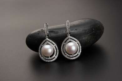 珍珠银饰耳环放在黑色的背景中