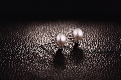  珍珠银饰耳环放在黑色的背景中