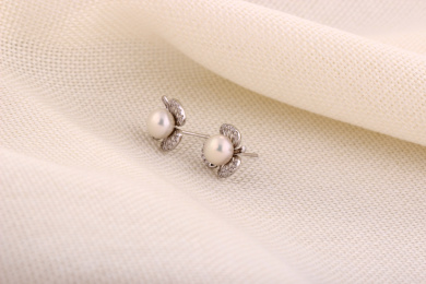 珍珠银饰耳环放在米白色的衬布上