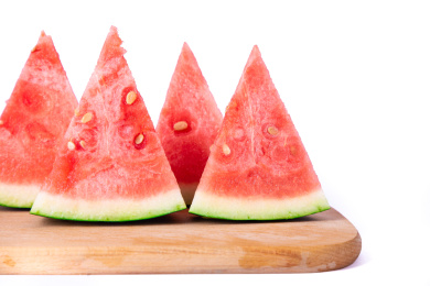 特写放在木板上的四片西瓜