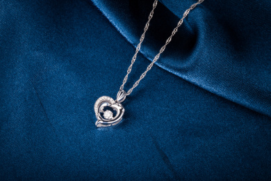 18K金钻石吊坠项链放在深蓝色的布上