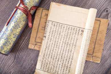 放好的毛笔和古书籍及旁边卷轴书画作品