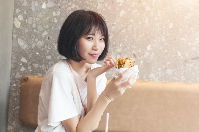 在餐厅拿着汉堡的女孩