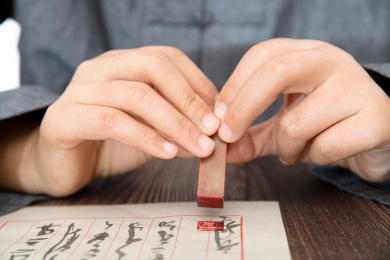 手拿印章在写好的信件上署名盖章