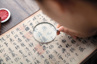 书法艺术家手持放大镜仔细欣赏王羲之的兰亭集序作品