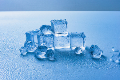 蓝色的冰块和晶莹的水珠在玻璃背景上