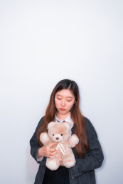 抱着娃娃思考的亚洲女孩