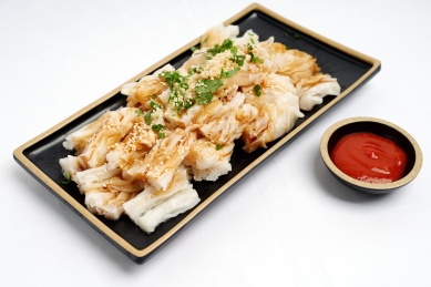 放在白色桌面上的一碟中国广东风味美食——捞粉(粉皮)侧视图