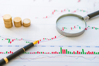 放大镜、金币和钢笔——股票金融概念图片