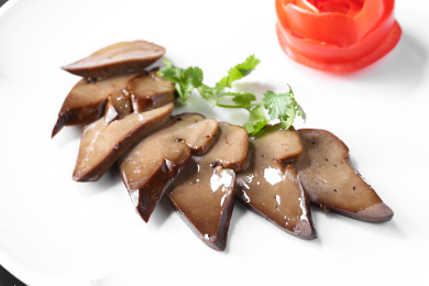 白色圆盘子里的卤鹅肝内脏粤菜卤菜