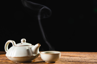 特写木桌上放着的冒热气的茶和茶壶