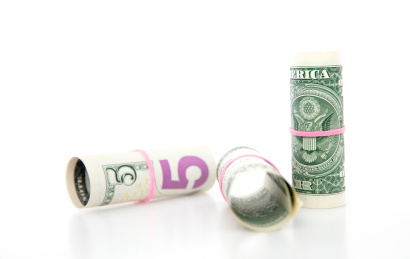 白背景上捆成筒状的美元钞票