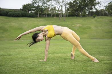 公园草地上练瑜伽的亚洲青年女子