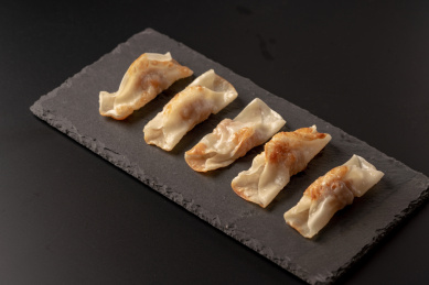 黑色桌面背景上的石岩板，以及石岩板上的煎饺