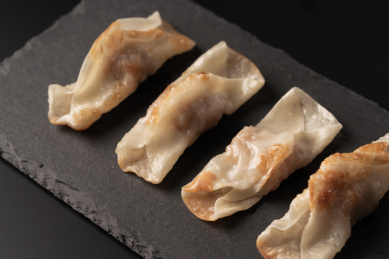 黑色桌面背景上的石岩板，以及石岩板上的煎饺