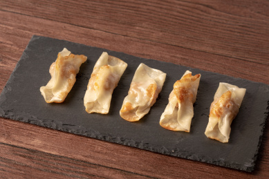 红褐色木板桌面上，石岩板上的煎饺