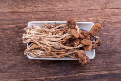 木纹桌子上有一碟茶树菇汤料