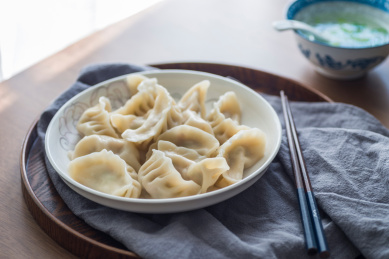实木餐桌上煮熟的中华传统美食饺子