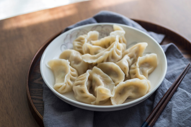 实木餐桌上煮熟的中华传统美食饺子