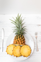 白色碟子一个切开的金钻凤梨（无眼菠萝）和一