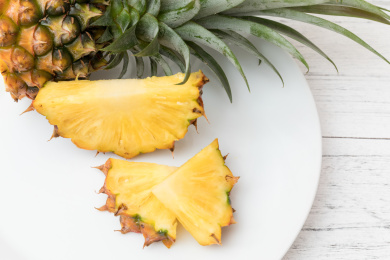 白色碟子上切开的热带水果金钻凤梨（无眼菠萝)