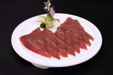 白色圆盘子里的汤锅火锅配菜,火锅食材新鲜牛肝片