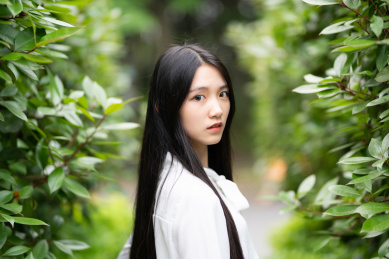  漂亮的女生在树林里回眸凝视