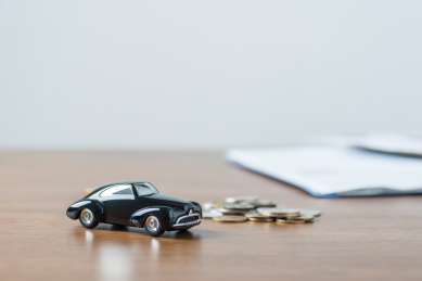 实木桌面上的复古汽车模型和钱币