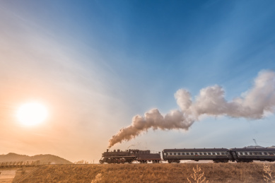 中国辽宁省铁岭市乡村田野的铁路和蒸汽机车