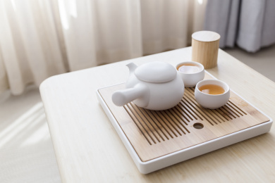 两杯热茶和一杯茶壶摆放在木桌上