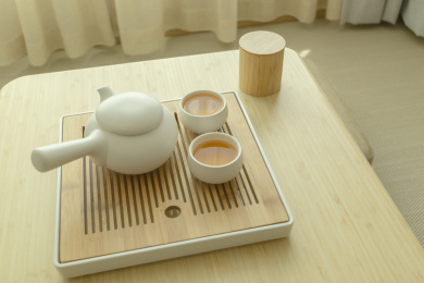 两杯热茶和一杯茶壶摆放在木桌上