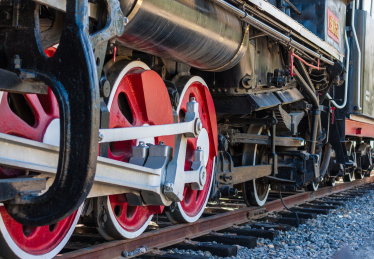 户外红黑涂装的老式蒸汽火车的驱动轮