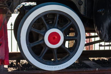 户外红黑涂装的老式蒸汽火车的驱动轮特写镜头