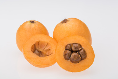 白色背景下剖开的黄色枇杷果特写