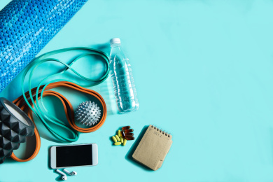 正上方视角蓝色背景特写放松运动的器材，水瓶，手机，营养品药片等