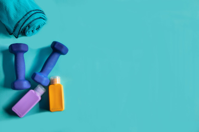 正上方视角蓝色背景特写哑铃和运动毛巾等沐浴清洁用品