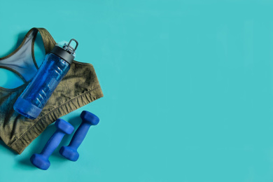 正上方视角蓝色背景特写运动内衣哑铃和运动水壶