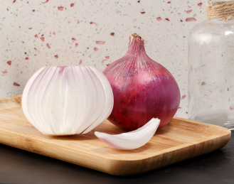 木盘上切开的洋葱切面和一个完整的洋葱