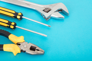 蓝色背景上的钳子和改锥等日常使用的工具