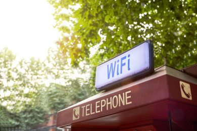 红色电话亭上的无线网络wifi标志绿色树叶背景中