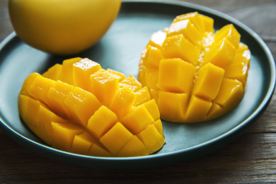 切好的芒果摆放在墨绿的盘子里