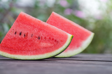 两块切好的西瓜放在户外的木桌上