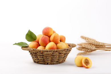 摆在桌上的一草篮新鲜水果——杏