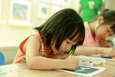 在桌子上用蜡笔涂色的两个小女孩