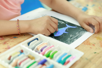 用彩色蜡笔涂色画画的小女孩