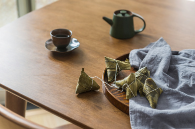 落地窗前的的木桌上放着的粽子和茶水
