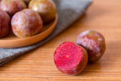 木纹桌面上新鲜美味的茂名钱排银妃三华李