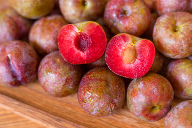 新鲜的茂名钱排银妃三华李的其中一个被切开露出紫红色果肉