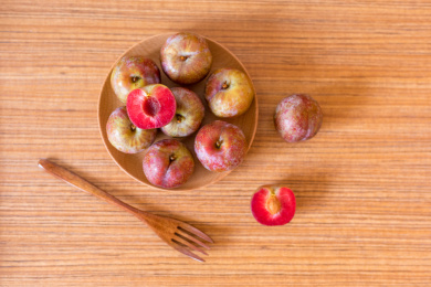 木纹桌面上一碟新鲜的茂名钱排银妃三华李