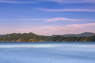 夕阳映照在云南省丽江市宁蒗县泸沽湖畔的群山上